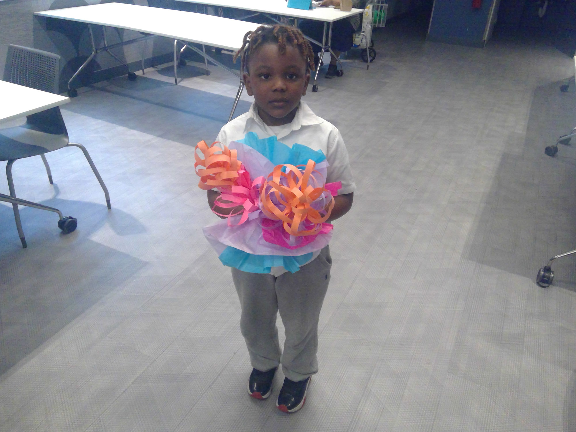 A child holds their paper craft flowers